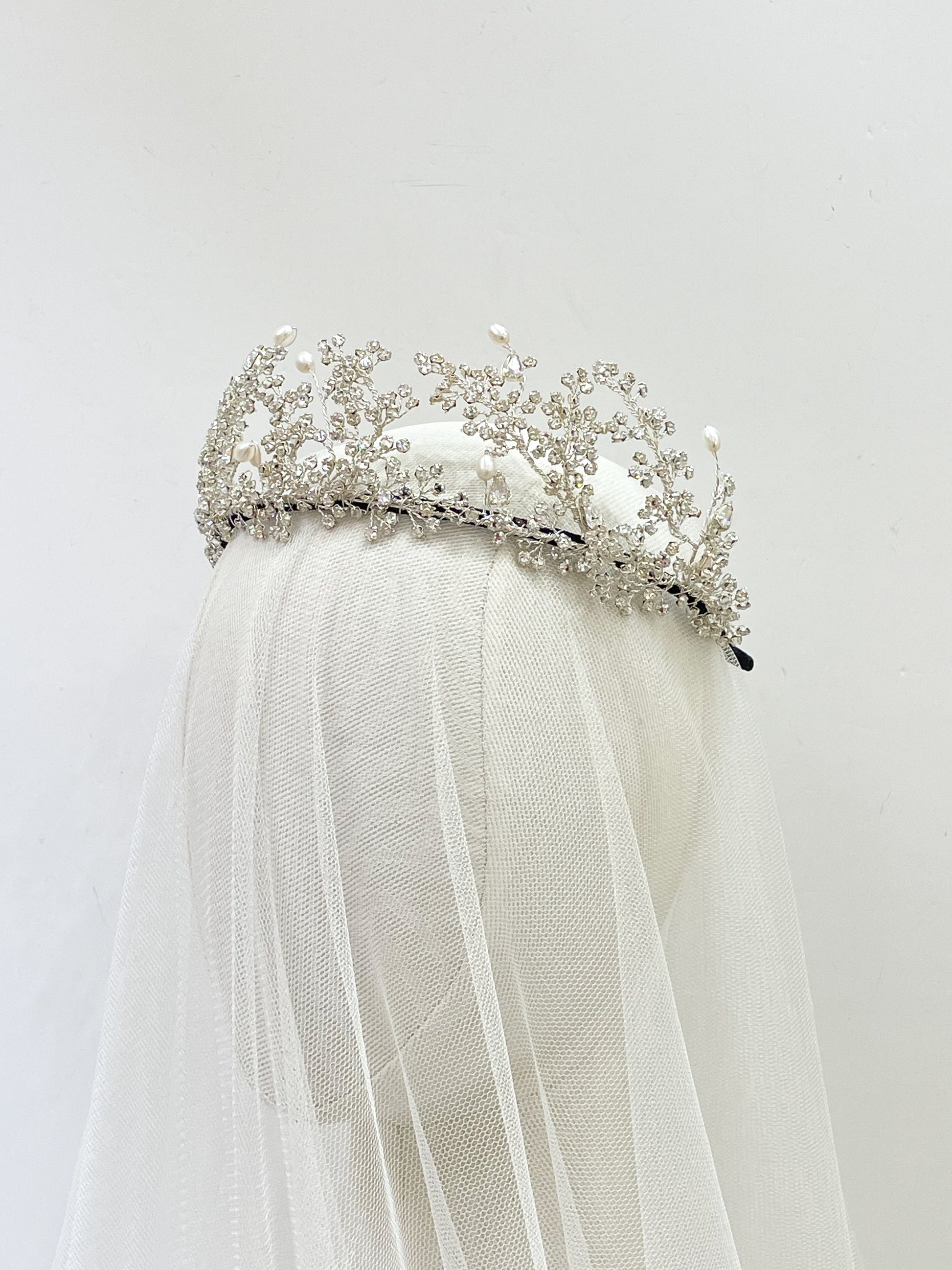 Wuthering Heights Silver tiara with pearls on a white veil against a light gray background
